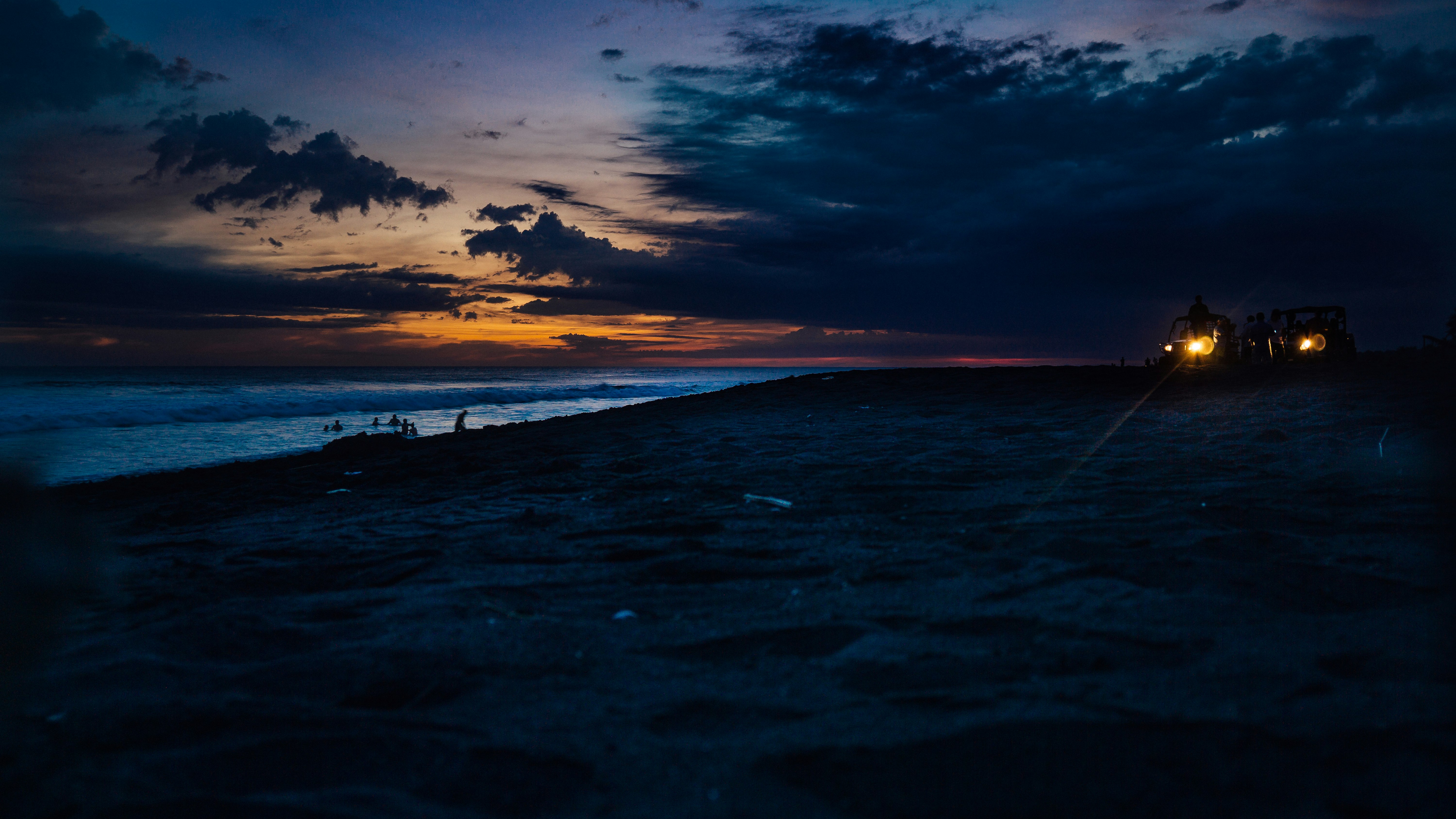 silhouette of person riding on car at the beach during dusk